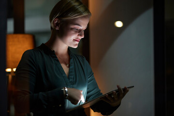 Late, night and woman typing on tablet in the evening in a modern office, workplace and startup company. Person, workaholic and female entrepreneur typing on laptop in the dark due to power cut - obrazy, fototapety, plakaty