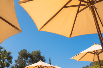 Yellow parasol umbrella on a blue sunny summer sky background © jordieasy