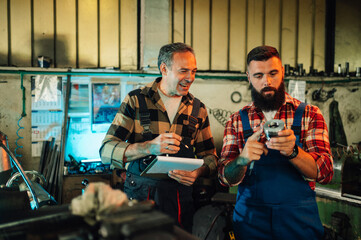 Two metallurgists writing down measures of a metal cylinder, smiling.