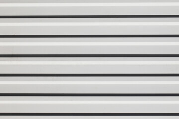 Corrugated metal sheet background. White paint metal stripes. Striped pattern. Garage door. Geometric lines metal wall.