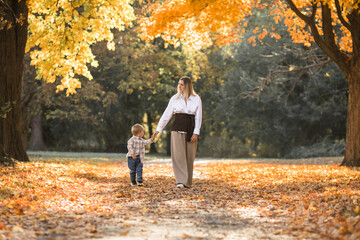 Fototapeta premium Mothers day, love family. Family on autumn walk in nature outdoors. Mother and child with hugging tenderness