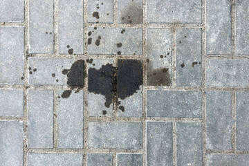 Leakage or leakage of oil from the car engine onto the paving slabs in a parking space, checking...