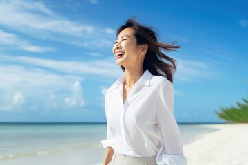 Asian woman walking on beach smiling happy