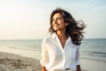 Fototapeta na wymiar Indian woman walking on beach smiling happy