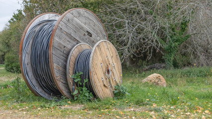 Large wooden spools of piping on the grass