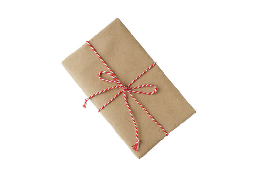 Christmas and New Year gift box wrapped in brown craft kraft paper with red and white baker's twine, ribbon bow isolated on white, transparent background, PNG