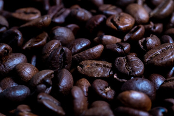 Macro roasted coffee beans close-up, top view. Full frame, blurred foreground