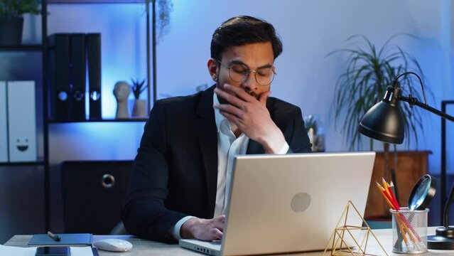 Irritated tired Indian business man while working on laptop, unexpected online website problem, computer virus data loss by hacking. Freelancer feeling mad about broken notebook at office workplace