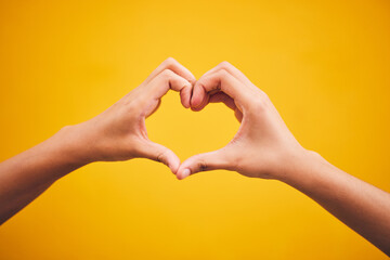 Heart, hands and person in studio with thank you, message or gesture on orange background space....