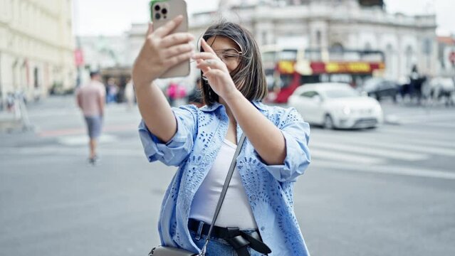 Young beautiful hispanic woman taking selfie with smartphone in the streets of Vienna