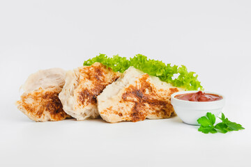 Chicken fillets fried until half cooked, semi-finished product with fresh herbs on a white background. Fast cooking.Fast homemade food.Fast food. Quick cooking at home. Copy space.