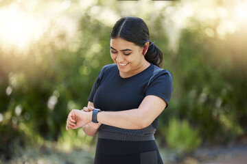 Woman, smartwatch and nature park running training, cardio exercise and fitness health with smile....