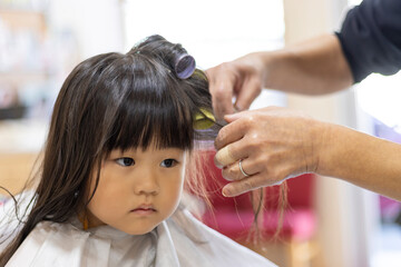 ヘアカーラーを巻かれる女の子（3歳、日本人） - obrazy, fototapety, plakaty