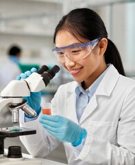 Female korean scientist working with microscope at laboratory