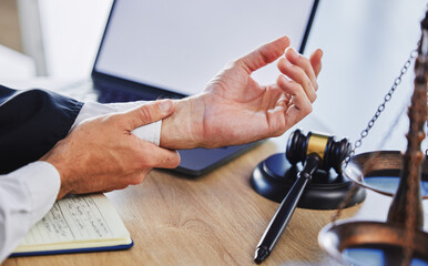 Hands of person, wrist and pain of lawyer at desk, office and law firm. Closeup of advocate, legal...