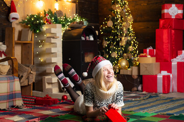 Happy dreamy young blonde woman in Santa's hat smile and looks so beautiful. Thoughts about winter...