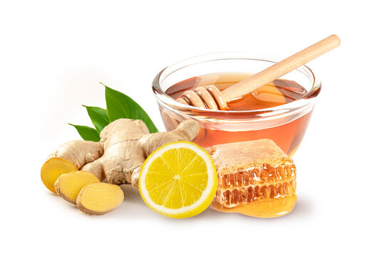 Glass bowl of honey with honey comb and fresh ginger root , lemon isolated on white background.