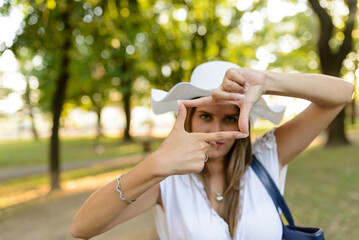 Portrait of playful woman using hands to make a frame