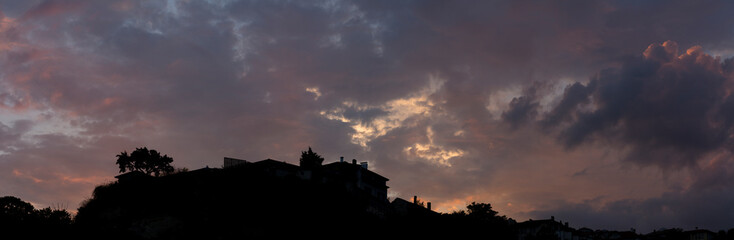 Colorful sunset over the Bulgarian town of Balchik. Cumulus clouds in a red-purple scale.