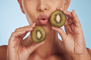 Fruit, pout and woman with kiwi for skincare or organic dermatology treatment isolated in a blue...