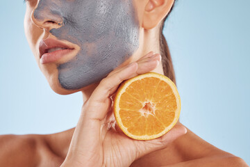 Closeup, woman and face mask with orange, skincare or dermatology against a blue studio background....