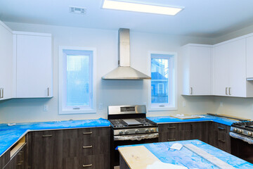 Installation of custom kitchen cabinets white color in new house with granite countertop