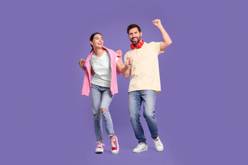 Fototapeta premium Happy couple dancing together on violet background