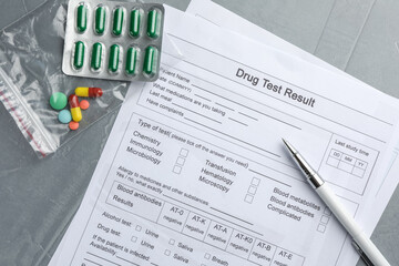 Drug test result form, pills and pen on grey table, flat lay