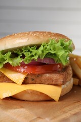 Delicious burger with tofu and fresh vegetables on wooden table, closeup