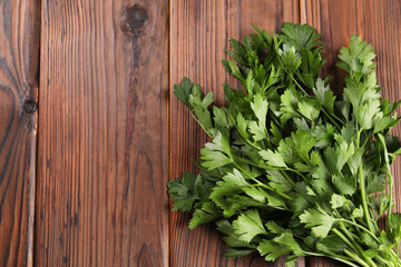 Bunch of fresh green parsley leaves on wooden table, top view. Space for text