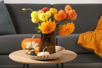 Fototapeten Beautiful autumn bouquet and pumpkins on coffee table near sofa in room © New Africa