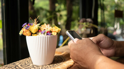 Yellow flowers in a white vase, Placed next to the window There was soft sunlight shining.