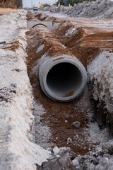 Laying sewer Concrete drainage pipe between large residential areas. New sanitary sewer, storm...