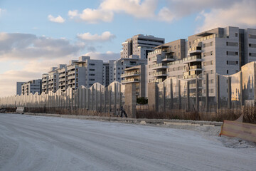 a road under construction in Israel, with new apartment buildings rising nearby. This development reflects the growth of a modern city in the country.