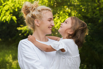 Beautiful mother with her cute daughter spending time together outdoors