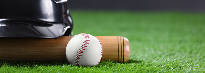 Baseball bat, batting helmet and ball on green grass, space for text. Banner design