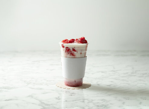 Iced strawberry latte in a takeout cup