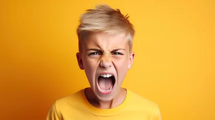 Foto op Canvas Angry irritated boy on yellow background. Full of rage. Emotional portrait of an upset preteen boy screaming in anger. Requirements for parents. Wrong perception. Hysterics. © Stavros