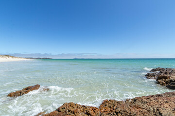 Puheke Beach with Crystal Clear Waters and White Sandy Shores with Coastal Rocks of Karikari Peninsula, Northland, New Zealand