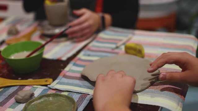 Pottery lesson master class for kids children, process of making clay pot on pottery wheel, potter wet hands creating ceramic crockery handcrafts, ceramist molding jar or vase
