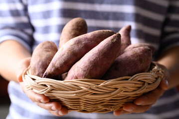 Purple sweet potato in basket holding by woman hand