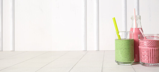 Glassware of tasty smoothies on white background with space for text