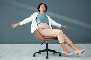 Chair, fun and carefree with a business black woman sliding on the floor of her office feeling stress free. Freedom, relax and success with a female employee riding a seat alone in the workplace - obrazy, fototapety, plakaty