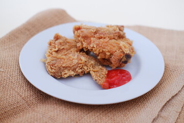 Crispy fried chicken on a plate with sauce, stock photo