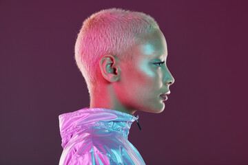 Holographic fashion, woman face and glow for hologram trend isolated on a studio background. Futuristic, vaporwave and art color jacket on cyberpunk model for retro cosmetics and makeup shine on skin