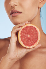 Woman, hands and grapefruit for vitamin C, skincare or diet against a blue studio background. Closeup of female person with organic citrus fruit for natural nutrition, dermatology or healthy wellness