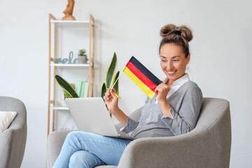 Mature woman with laptop studying German online at home
