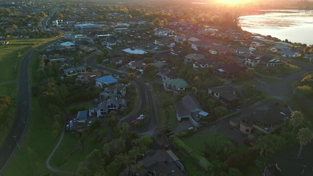 Sunset aerial view of coastal neighborhood in Akaroa, New Zealand, overlooking Mount Manganui