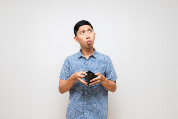 Asian poor man blue shirt holding empty wallet feels worried about no money isolated - obrazy, fototapety, plakaty