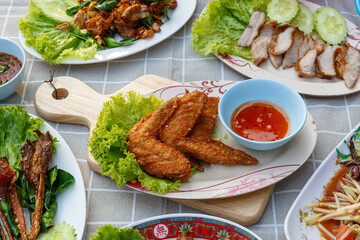 Hot fried chicken wings in Som Tum (Papaya Salad) Thai food culture.